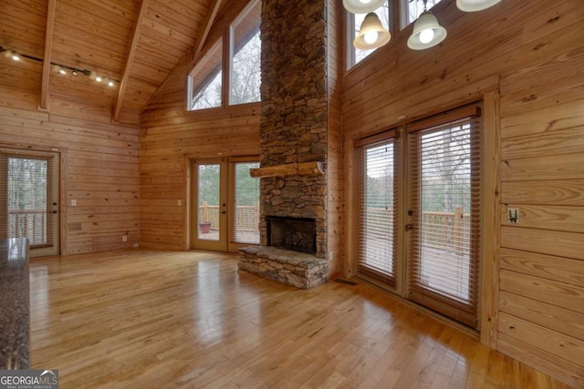 236 William Branch Rd, Morganton, GA 30560 - unfurnished living room featuring wood walls, hardwood / wood-style floors, a stone fireplace, high vaulted ceiling, and wood ceiling