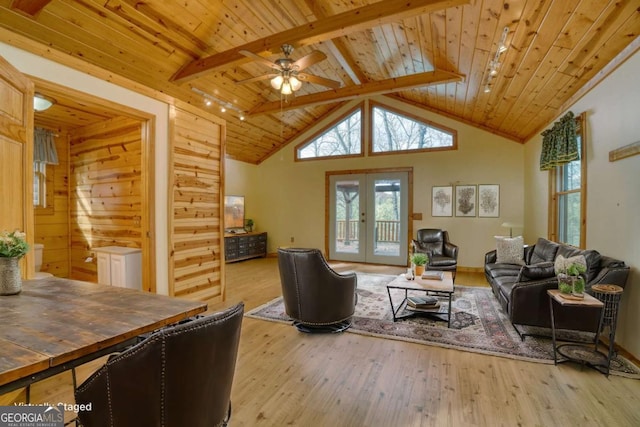 living room featuring wood walls, french doors, light wood-type flooring, beamed ceiling, and wood ceiling