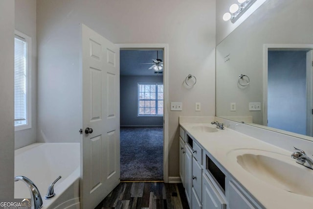 bathroom with a bath, vanity, ceiling fan, and hardwood / wood-style floors