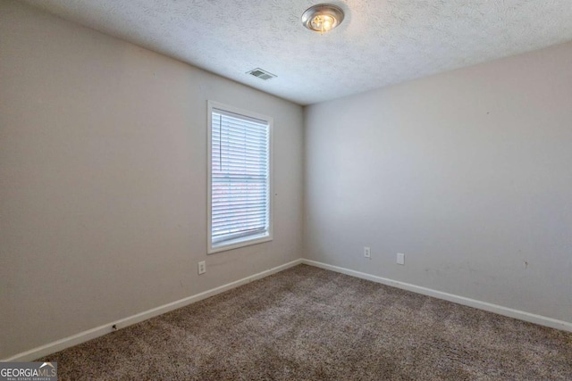 unfurnished room with carpet flooring and a textured ceiling