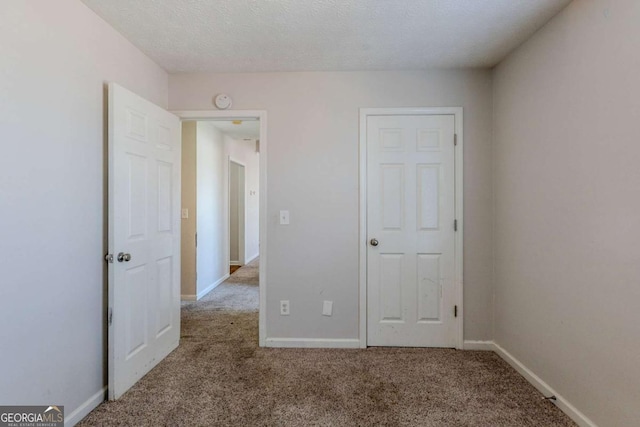 unfurnished bedroom with carpet flooring and a textured ceiling