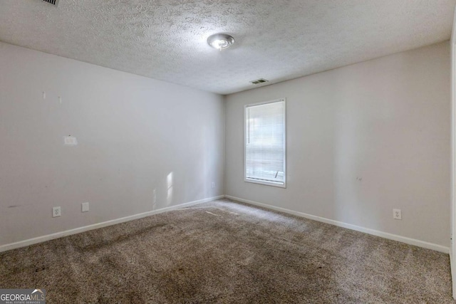 carpeted spare room with a textured ceiling