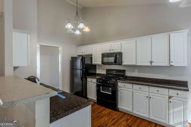 kitchen with white cabinetry, high vaulted ceiling, black appliances, and an inviting chandelier