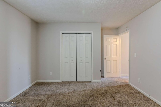 unfurnished bedroom featuring a closet, carpet, and a textured ceiling