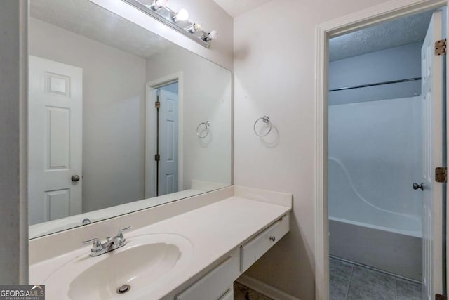 bathroom featuring vanity, a textured ceiling, and tile patterned floors