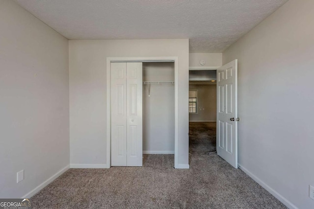 unfurnished bedroom with a closet, carpet floors, and a textured ceiling