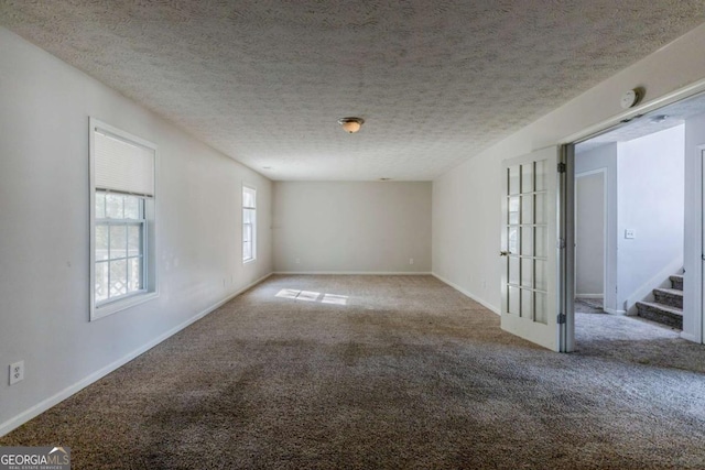 carpeted spare room with a textured ceiling