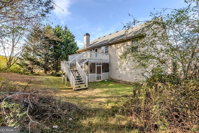 rear view of house with a wooden deck and a yard