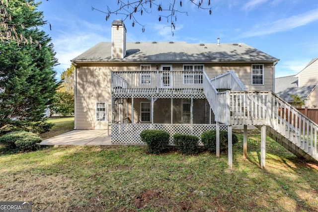 back of property with a sunroom, a yard, a patio, and a wooden deck