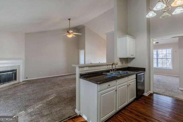 kitchen with high vaulted ceiling, white cabinets, sink, dark hardwood / wood-style floors, and black dishwasher