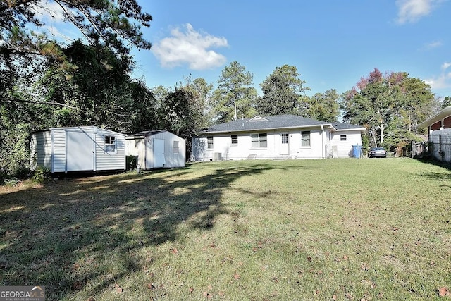 rear view of house featuring a shed and a yard