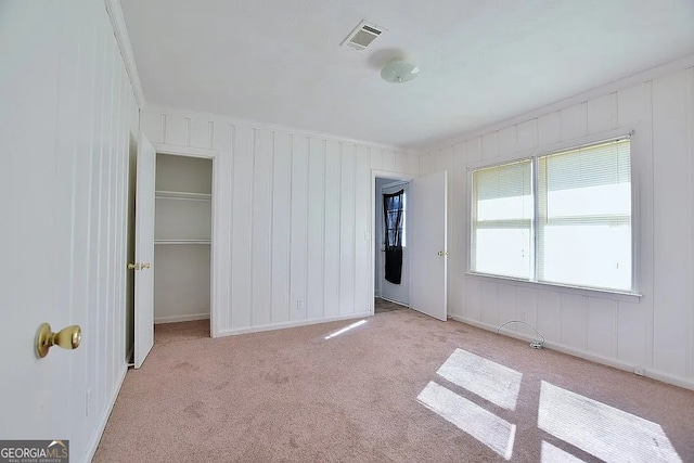 unfurnished bedroom with light carpet and a closet