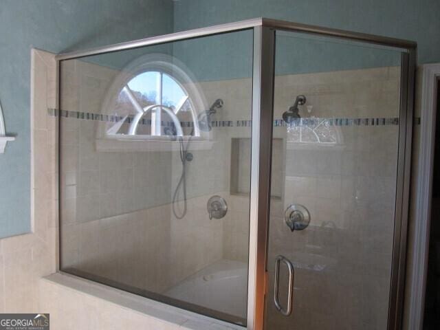 bathroom featuring a shower with shower door