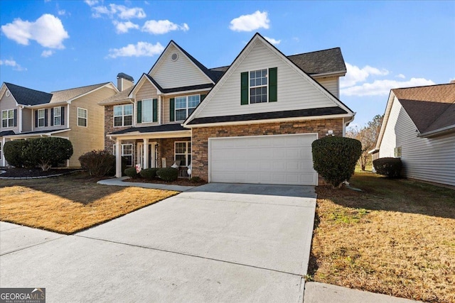 view of front of home with covered porch, a front yard, and a garage