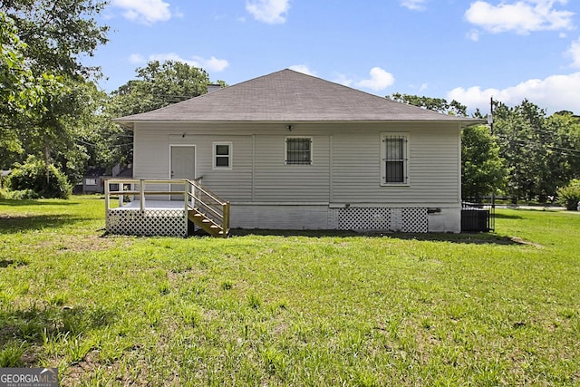 rear view of house with cooling unit, a yard, and a wooden deck