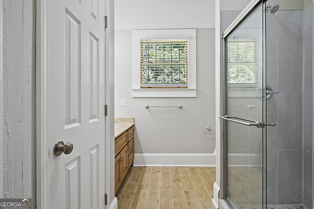 bathroom with hardwood / wood-style floors, vanity, an enclosed shower, and a wealth of natural light