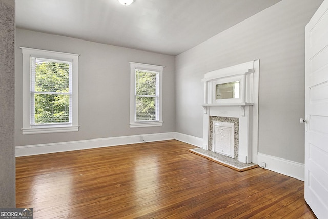 unfurnished living room featuring a wealth of natural light and wood-type flooring