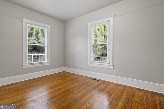 spare room featuring hardwood / wood-style floors and a wealth of natural light