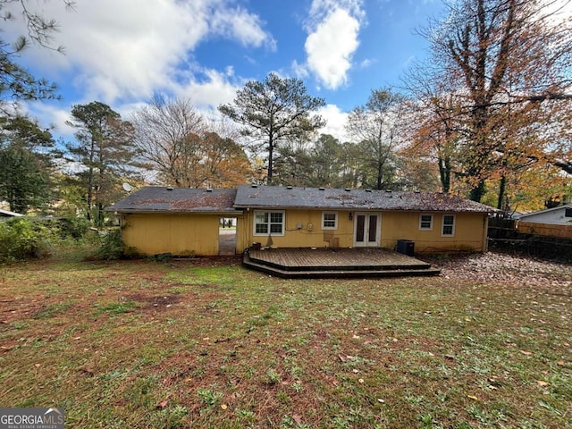 rear view of house with a lawn, french doors, and a deck