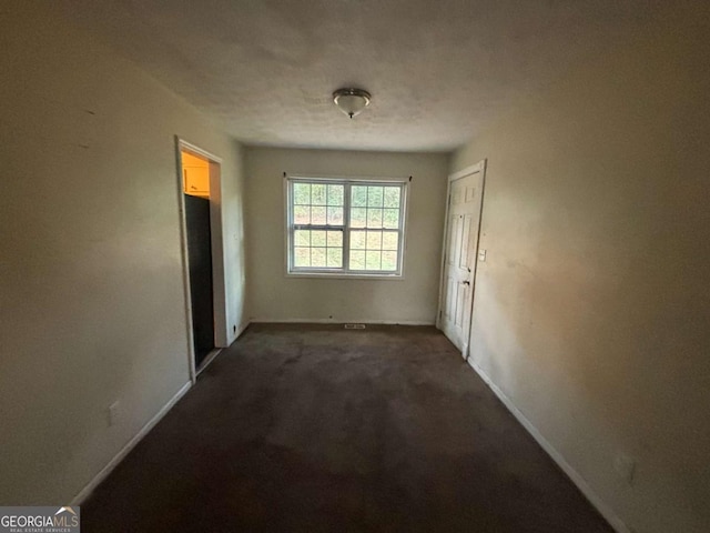 empty room featuring dark carpet