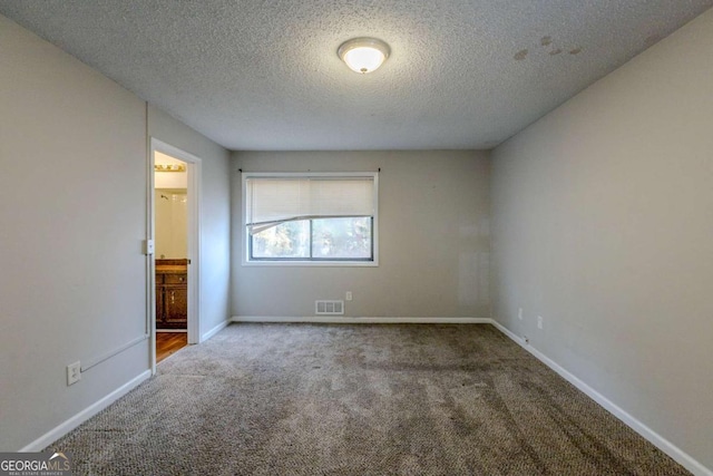 carpeted spare room with a textured ceiling