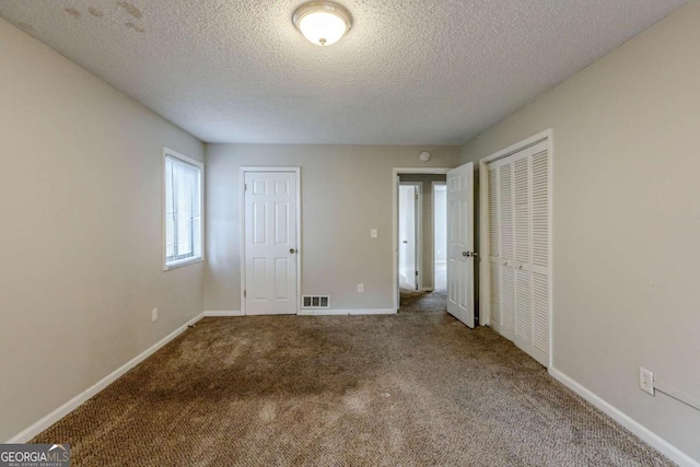 unfurnished bedroom featuring carpet flooring and a textured ceiling