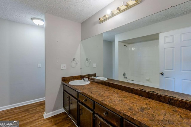 bathroom featuring walk in shower, vanity, a textured ceiling, and hardwood / wood-style flooring