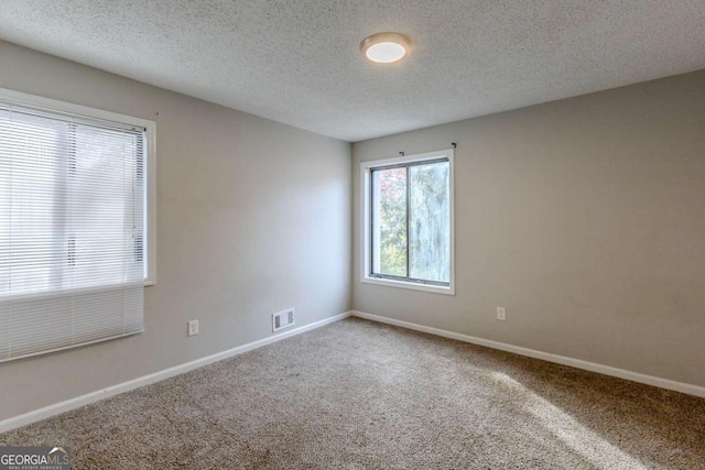 unfurnished room featuring a textured ceiling and carpet floors