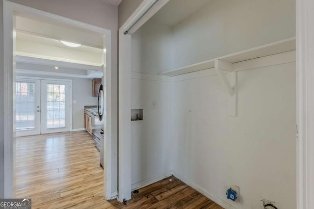 clothes washing area featuring light hardwood / wood-style floors, hookup for a washing machine, and french doors