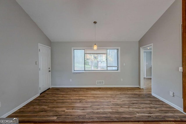 unfurnished dining area with dark wood-type flooring and lofted ceiling