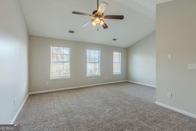 empty room with carpet, a textured ceiling, vaulted ceiling, and ceiling fan