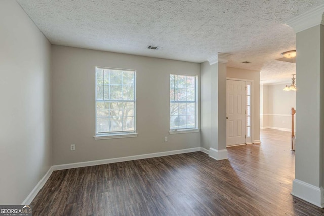 empty room featuring a textured ceiling, an inviting chandelier, and dark wood-type flooring