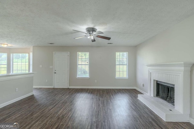 unfurnished living room featuring a textured ceiling, ceiling fan, a fireplace, and dark hardwood / wood-style floors