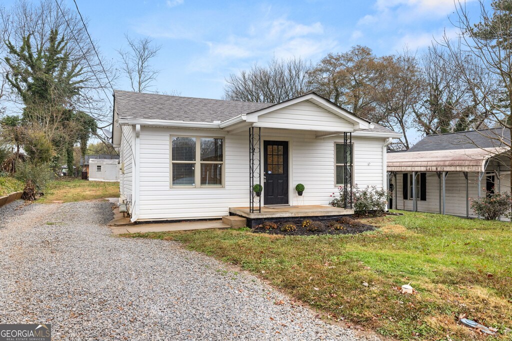 view of front of house with covered porch and a front lawn