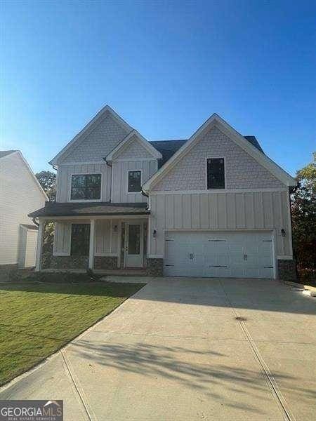 view of front of property with a front yard, a porch, and a garage