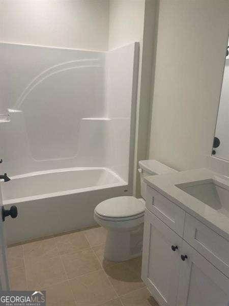 full bathroom featuring tile patterned floors, vanity,  shower combination, and toilet