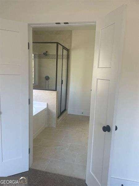 bathroom featuring tile patterned floors and separate shower and tub