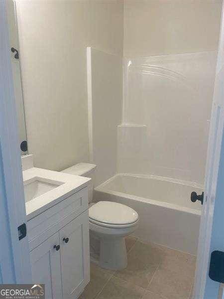 full bathroom with tile patterned floors, vanity,  shower combination, and toilet