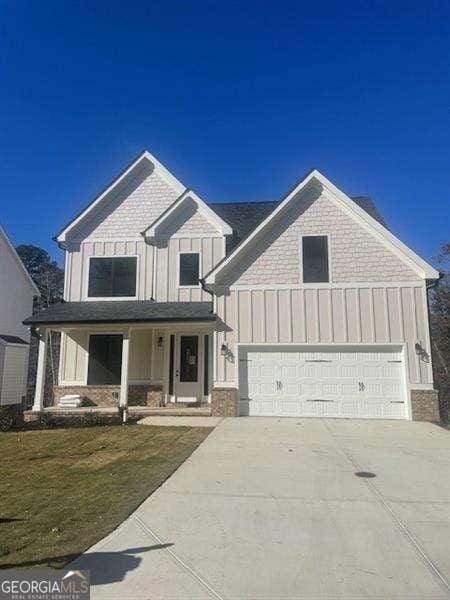 view of front of property featuring a front yard, a garage, and covered porch