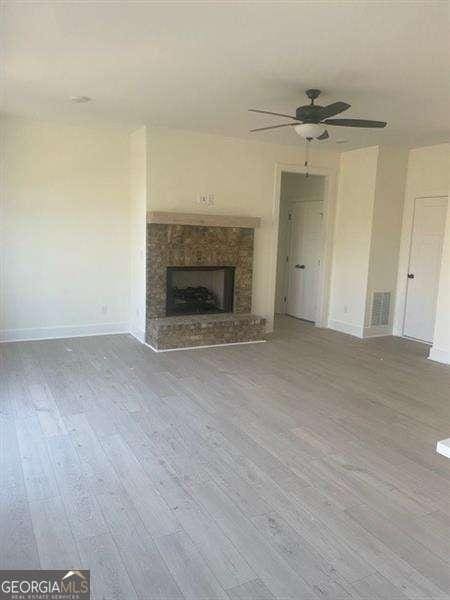 unfurnished living room featuring ceiling fan and wood-type flooring