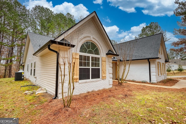 view of home's exterior featuring a lawn and central AC