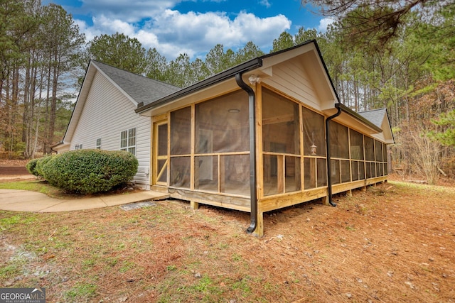 view of property exterior with a sunroom