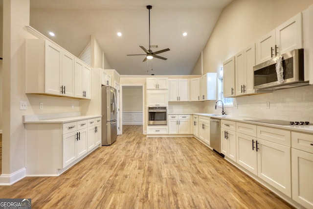 kitchen featuring sink, white cabinets, stainless steel appliances, and light wood-type flooring