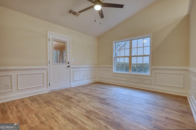 spare room featuring ceiling fan, lofted ceiling, and light wood-type flooring