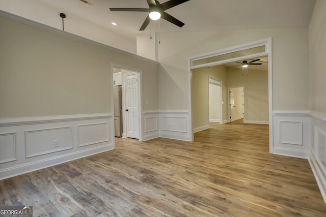 empty room featuring ceiling fan, light hardwood / wood-style floors, and vaulted ceiling