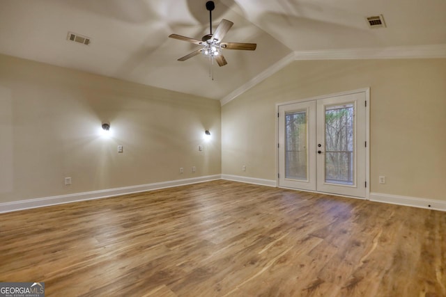 unfurnished room with ceiling fan, vaulted ceiling, light wood-type flooring, and french doors