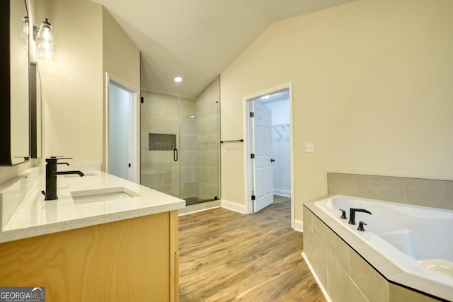 bathroom featuring separate shower and tub, vanity, wood-type flooring, and lofted ceiling