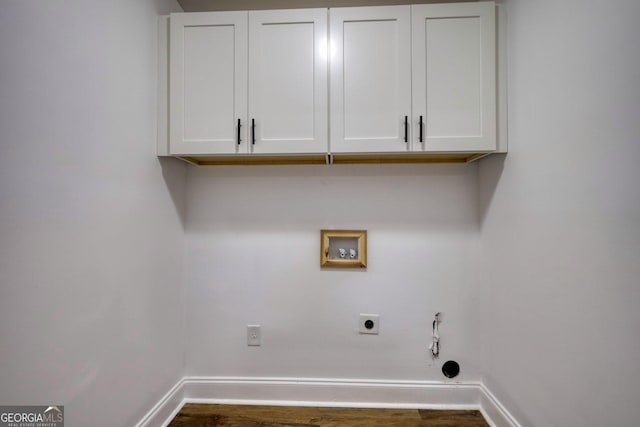 laundry room featuring electric dryer hookup, cabinets, gas dryer hookup, hookup for a washing machine, and dark hardwood / wood-style floors