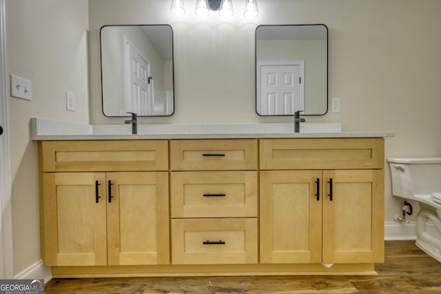 bathroom with hardwood / wood-style floors, vanity, and toilet