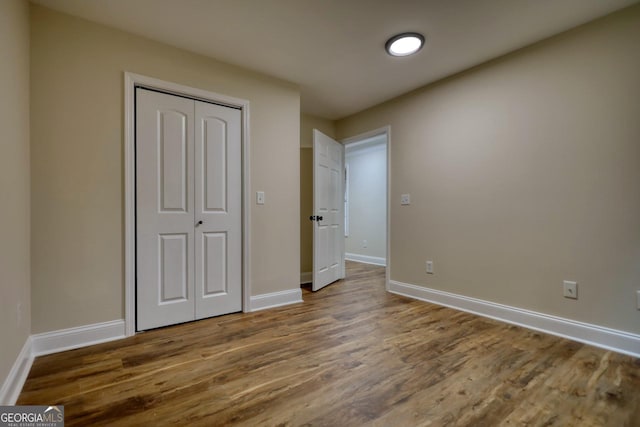 unfurnished bedroom with wood-type flooring and a closet